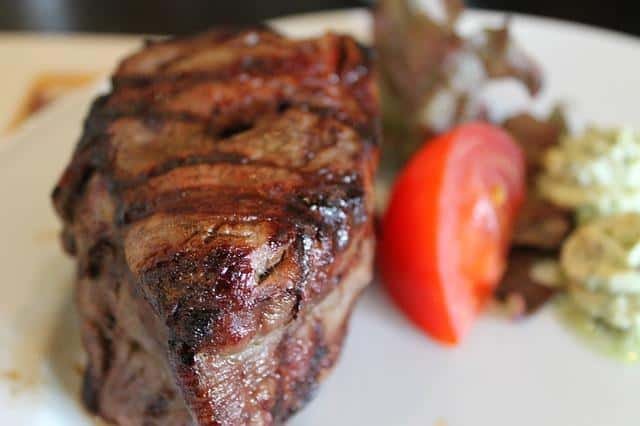 A closeup of steak with garnish