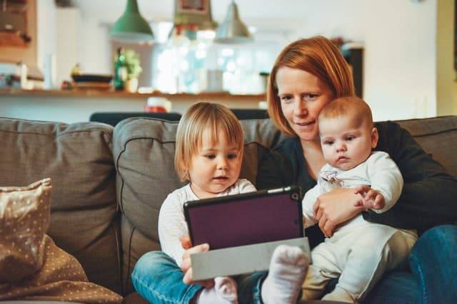 Trabalhos para mães que ficam em casa: mãe e dois bebês olhando para um computador