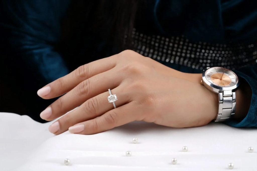 Hand shows diamond ring and wristwatch. Two of the most sought after consumer durable goods.